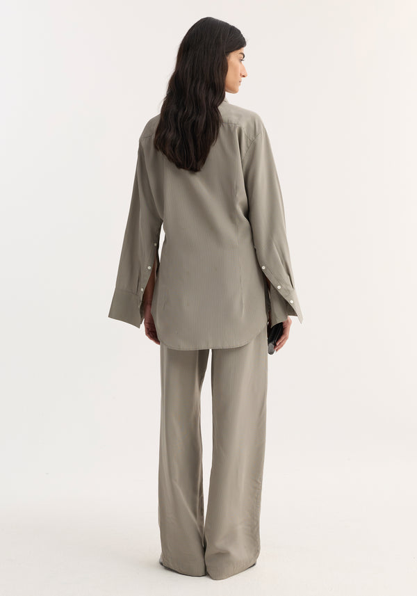 Woman in Relaxed shaped shirt with a loose, hourglass fit, elongated sleeve plackets, and mother-of-pearl buttons, paired with matching wide-leg trousers.