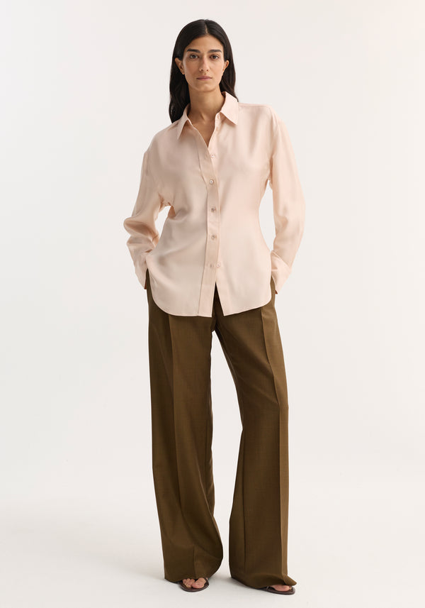Model wearing Silk Shaped Shirt | Rose in a relaxed fit with an open collar, paired with high-waisted trousers and sandals, showcasing a sophisticated, fluid silhouette.