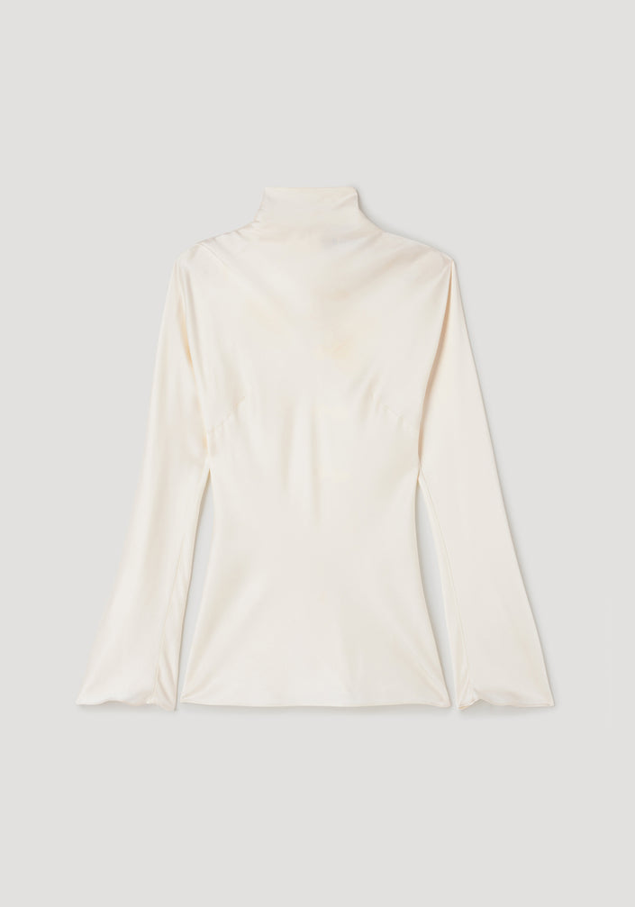 Person wearing Satin waisted top | cream in a sleek, long-sleeve design with a high neckline paired with black slim trousers and black strappy heels against a plain background.
