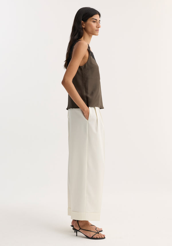 V-neck silk lace top | earth shown on model in profile, featuring delicate lace trim and sleeveless design, paired with high-waisted trousers and strappy sandals.
