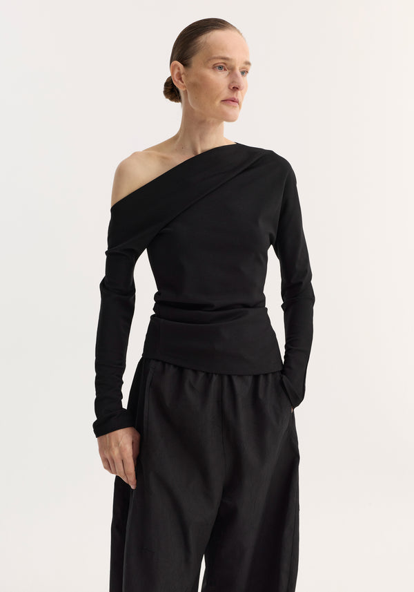 Woman in a Twisted jersey top | black, featuring a one-shoulder neckline and long sleeves, with a draped twist at the waist for a sculpted look.
