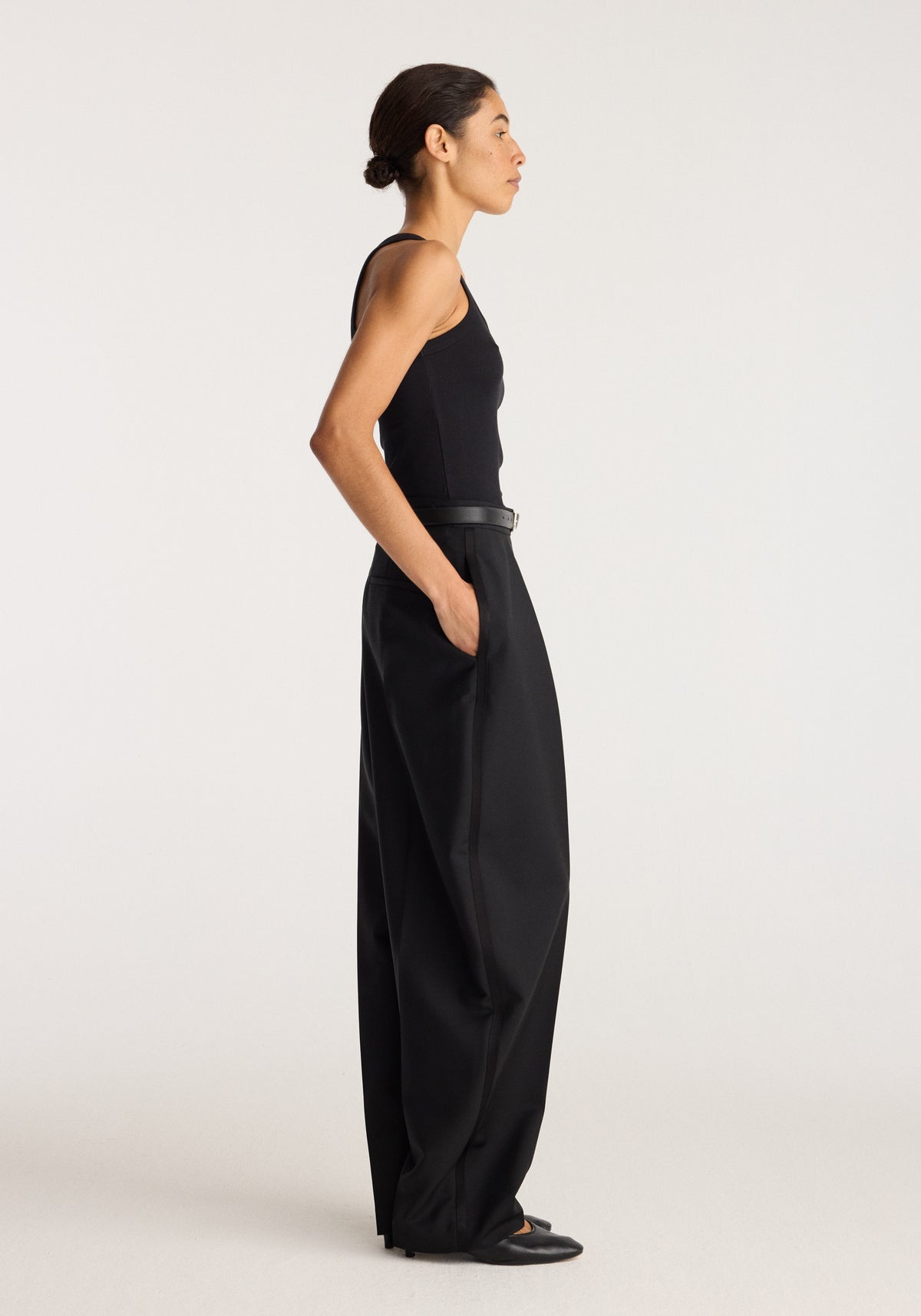 Merino scoop neck top | black worn by a model in side profile with a sleeveless scoop neckline and fitted silhouette