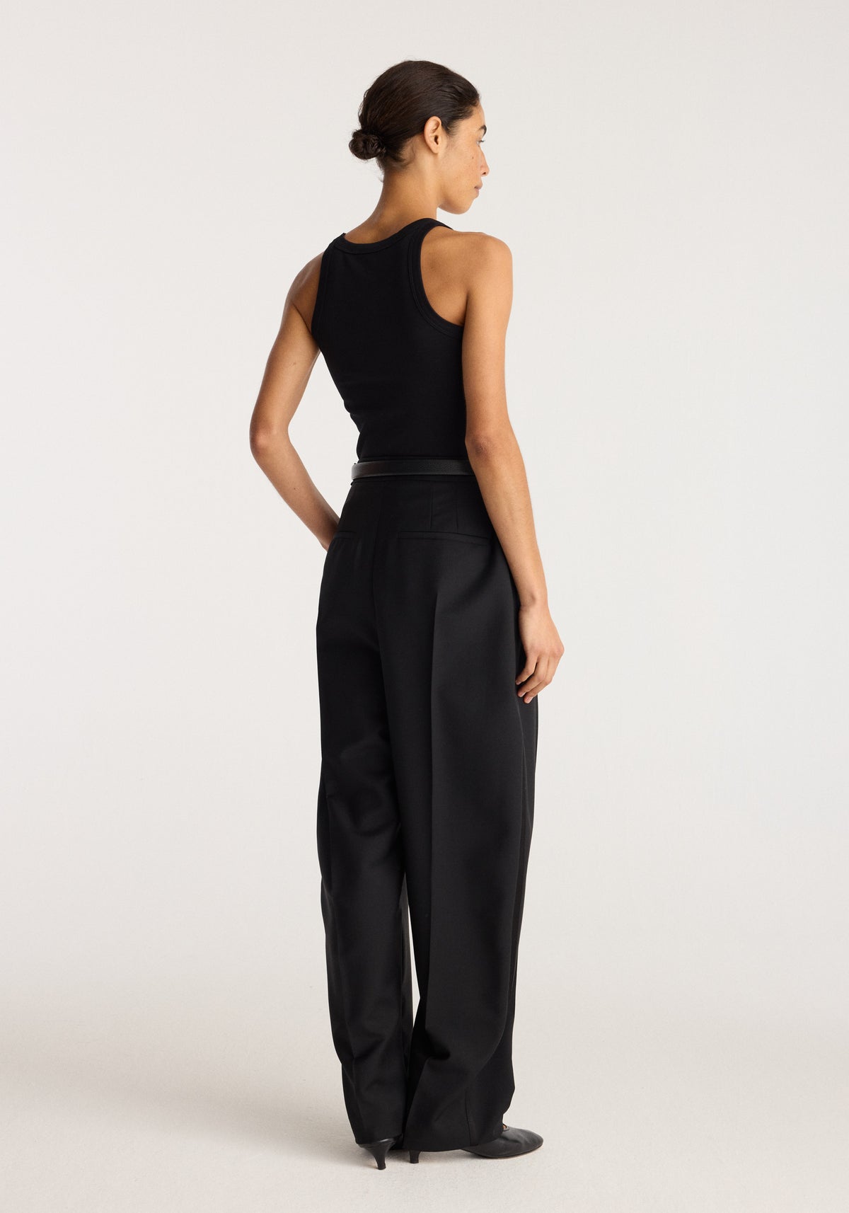 Merino scoop neck top | black shown from the back on a model with a fitted sleeveless silhouette and scoop back neckline