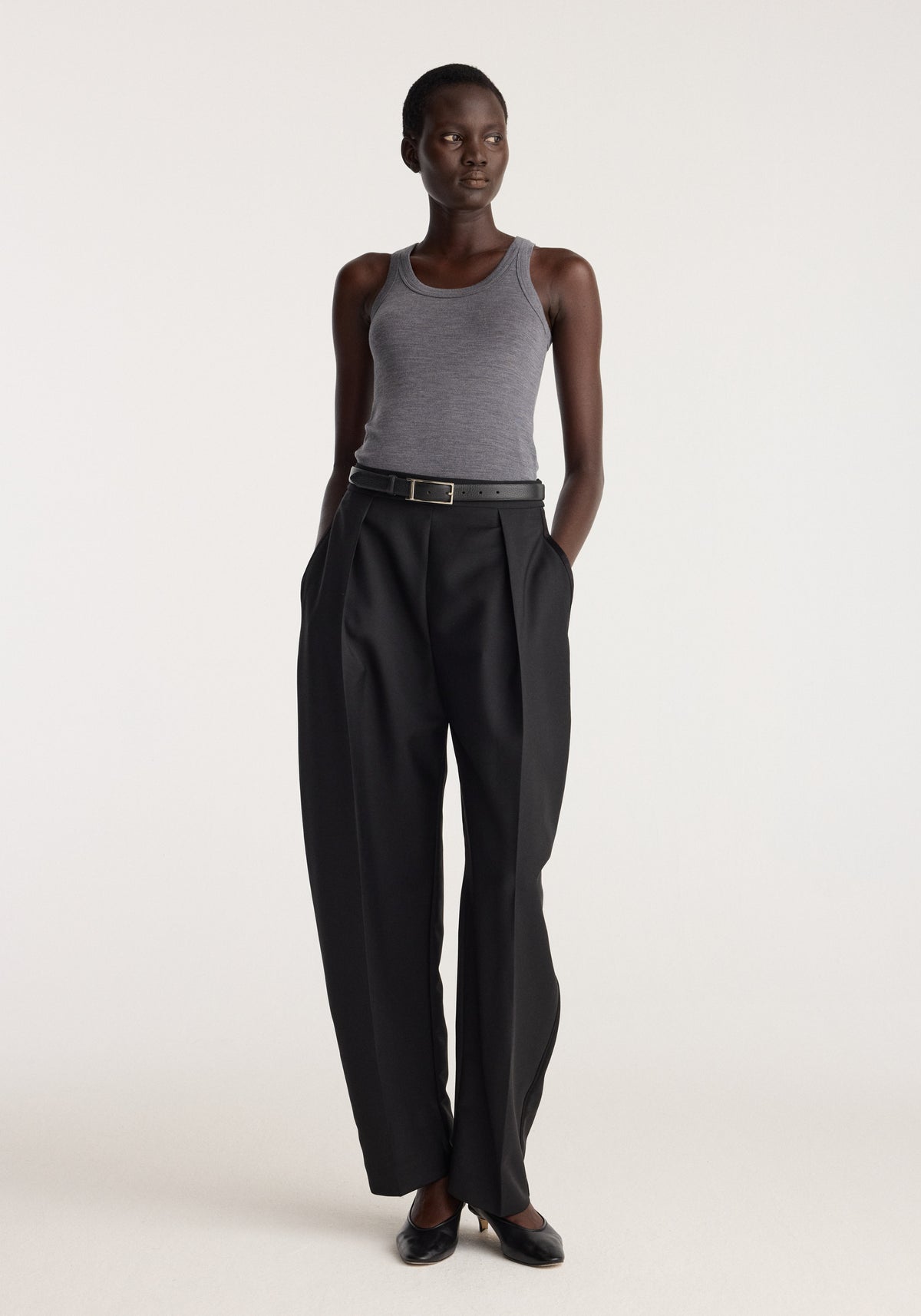 Merino scoop neck top | mid grey melange worn by a model with black trousers and loafers against a neutral background