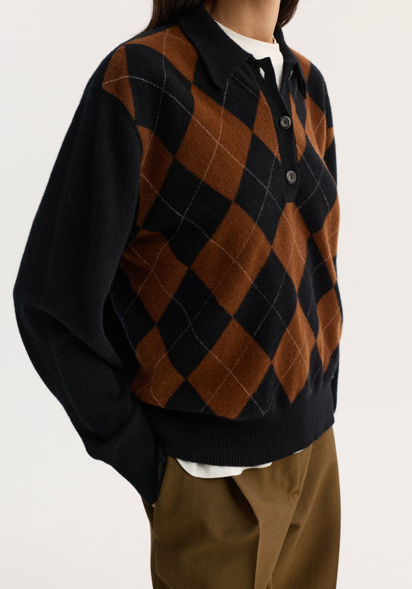Compact knitted check polo with a structured collar and three-button placket, showcasing a black rust argyle pattern over a white shirt and brown trousers.