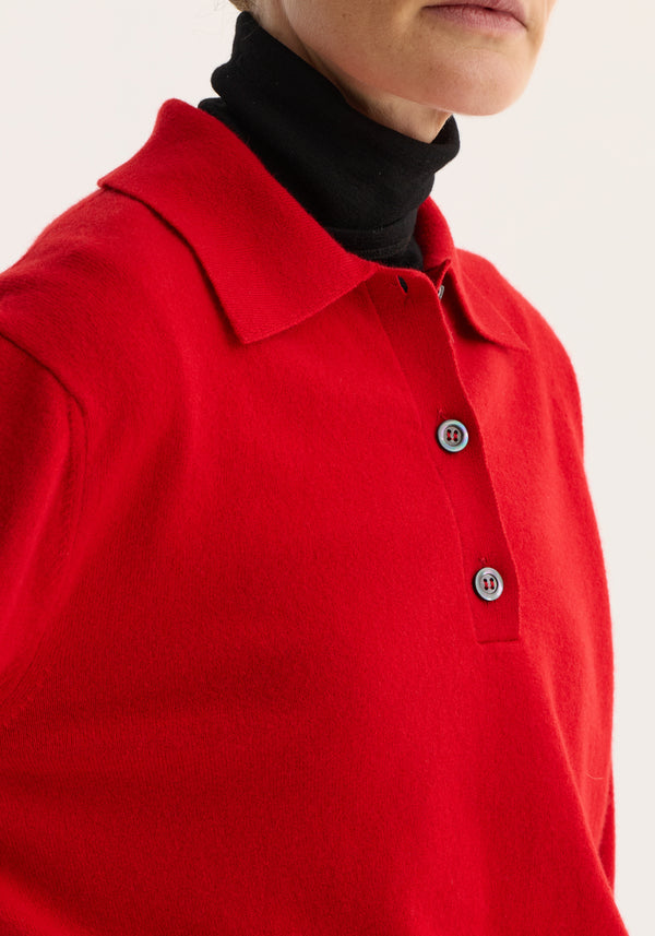 Model wearing Wool Cashmere Polo in red, showcasing a structured collar with visible two-button closure over a black turtleneck layer.