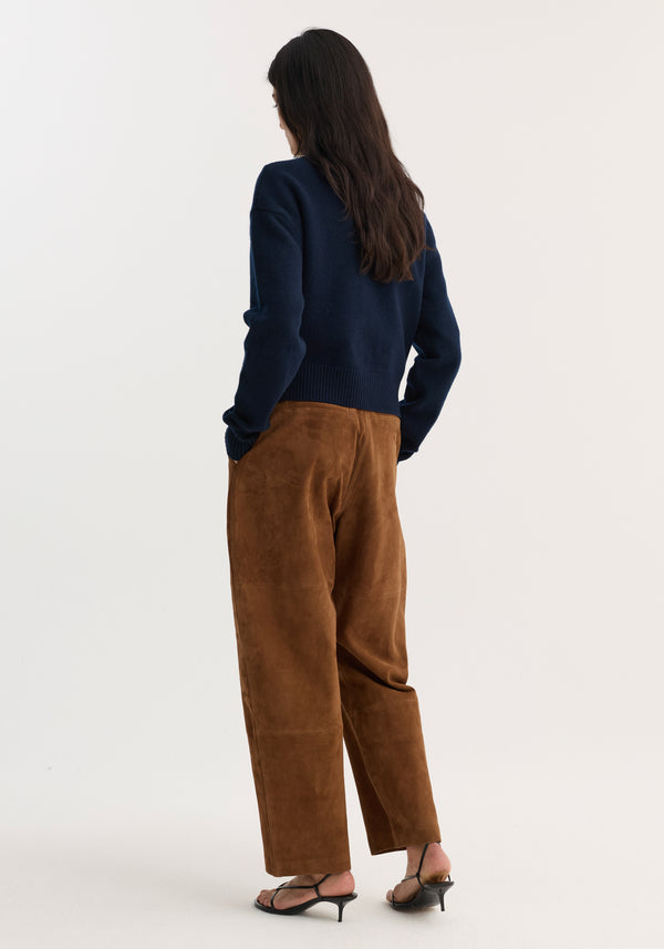 Model in Suede barrel leg trouser | tobacco, showcasing wide-leg suede trousers with panel seams, back pockets, and a high waist, paired with black sandals.