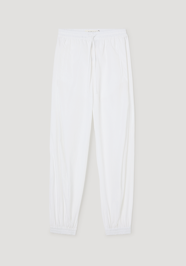 Balloon track pants in optic white, featuring a crinkled texture, elastic waistband with drawstring, side pockets, and elastic cuffs for a voluminous leg style.