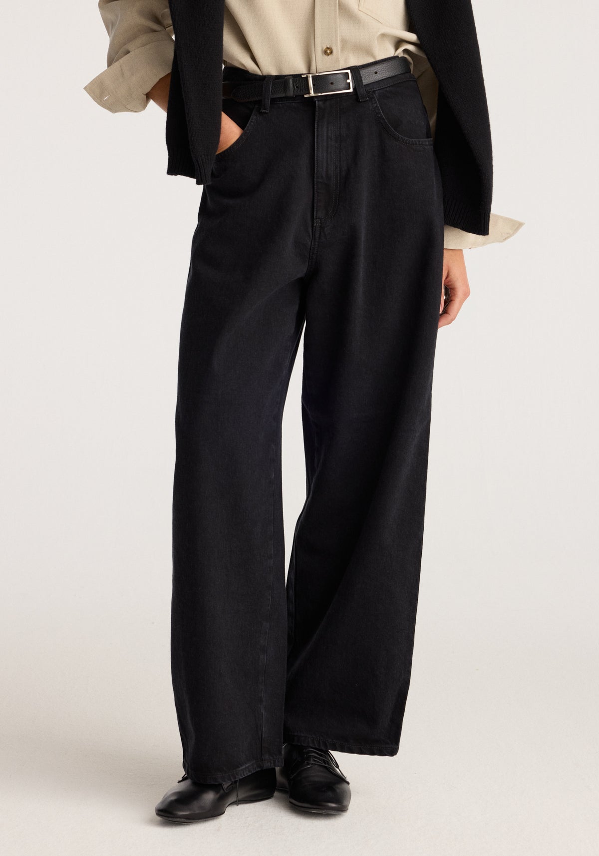 Berber - Barrel leg denim | black shown on a model with a high waist wide barrel legs belt loops and front pockets styled with black shoes