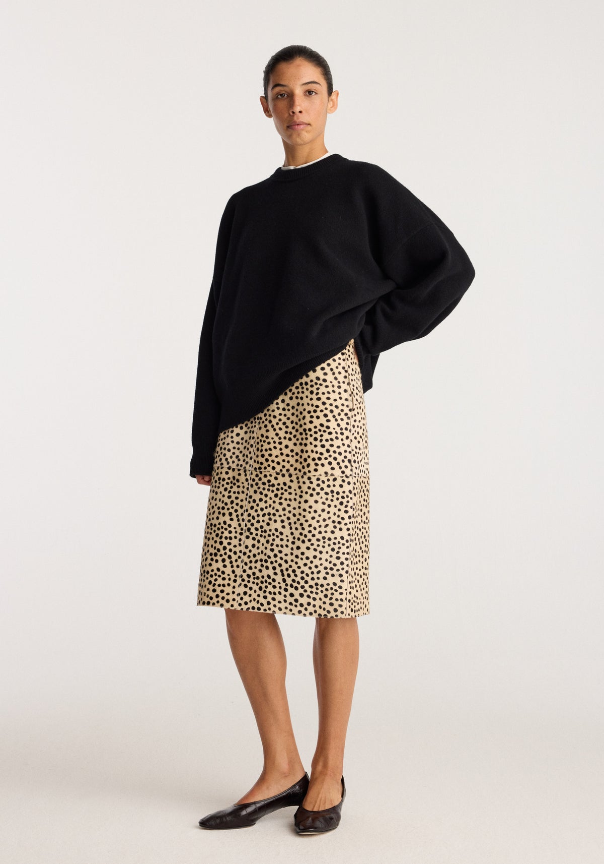 Pony hair pencil skirt | cheetah worn with a black oversized sweater and black flats on a model in a studio