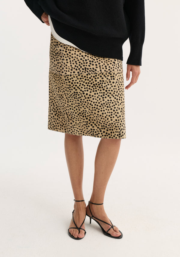 Model in a black sweater and heeled sandals wears a Pony hair pencil skirt | cheetah, showcasing its sleek, fitted silhouette and distinctive print.