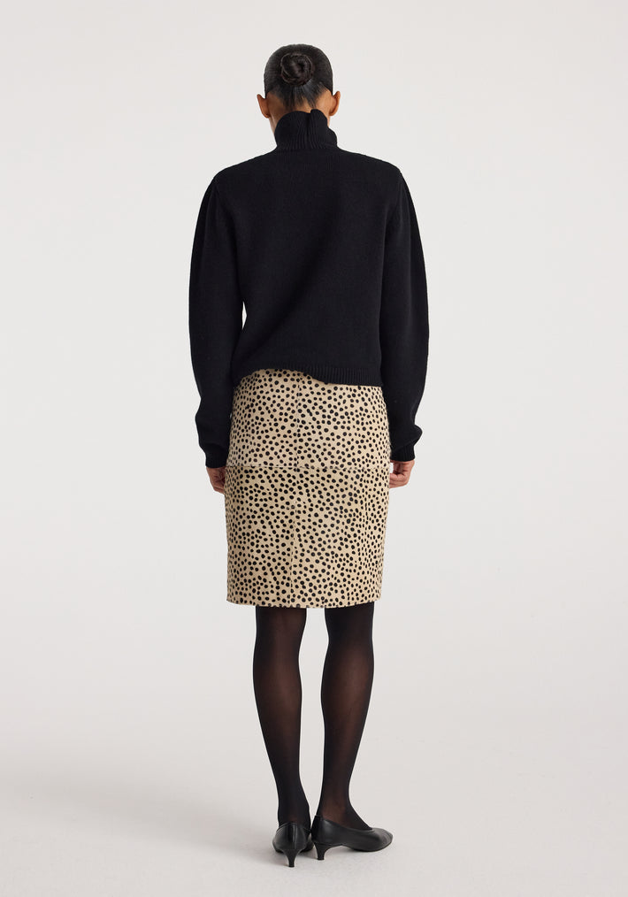 Woman wearing a black turtleneck sweater paired with a beige Pony hair pencil skirt | cheetah with black spots, black tights, and black heels, shown from the back.