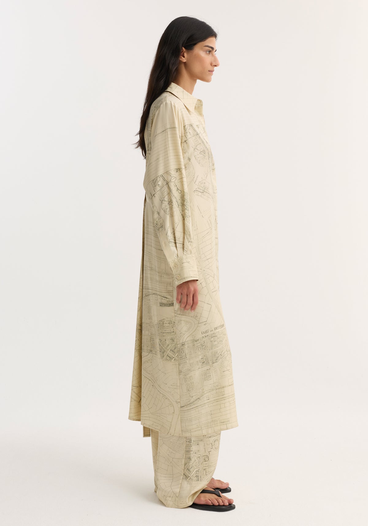 Model in profile wearing Silk open back wrap dress with map print and matching trousers, featuring button-down front and wrap tie detail for versatile fit.