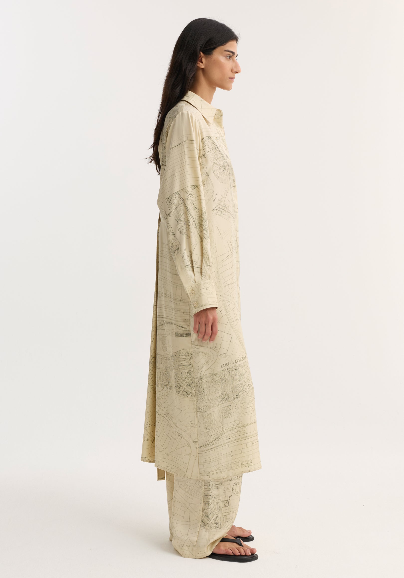 Model in profile wearing Silk open back wrap dress with map print and matching trousers, featuring button-down front and wrap tie detail for versatile fit.