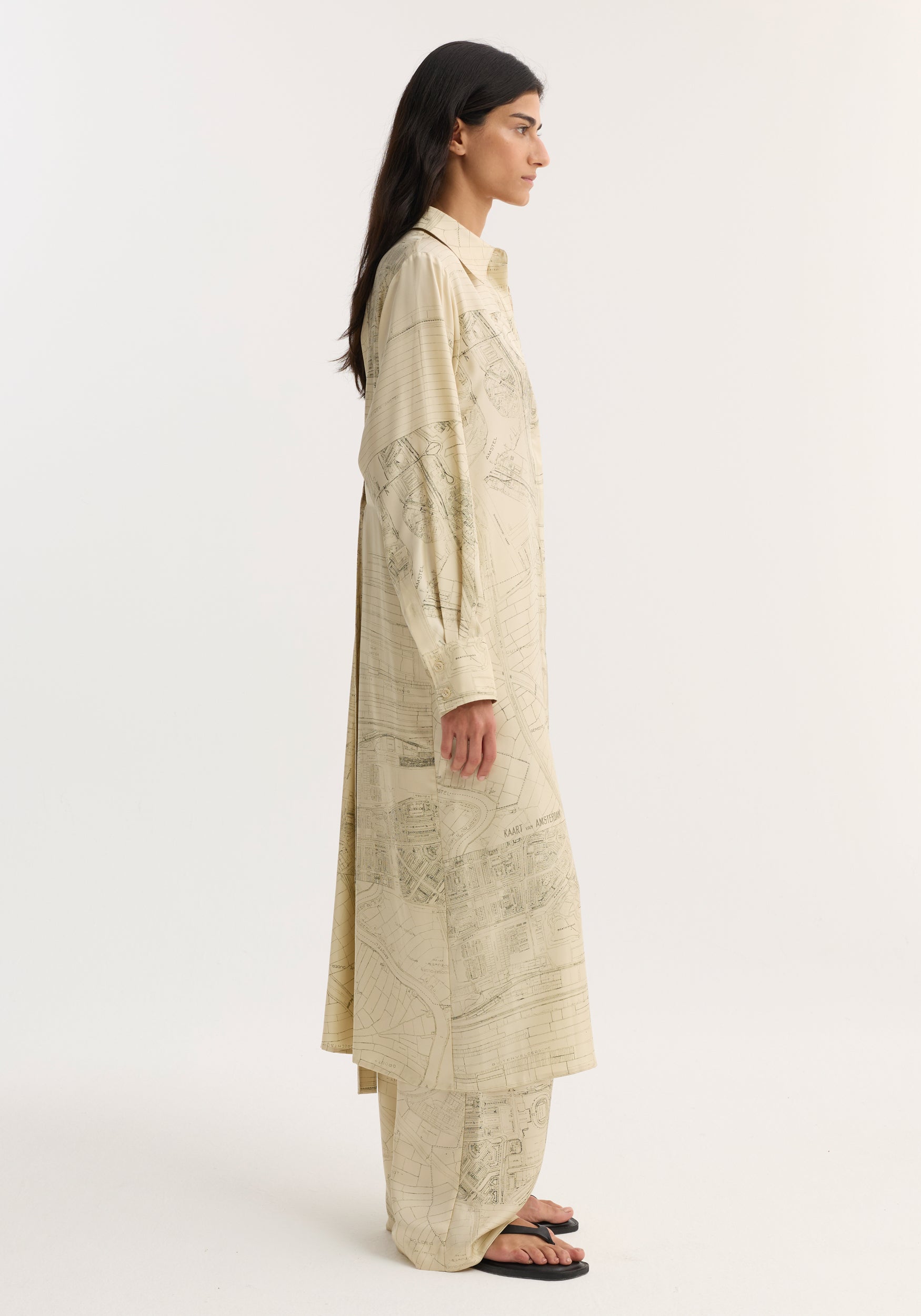 Model in profile wearing Silk open back wrap dress with map print and matching trousers, featuring button-down front and wrap tie detail for versatile fit.