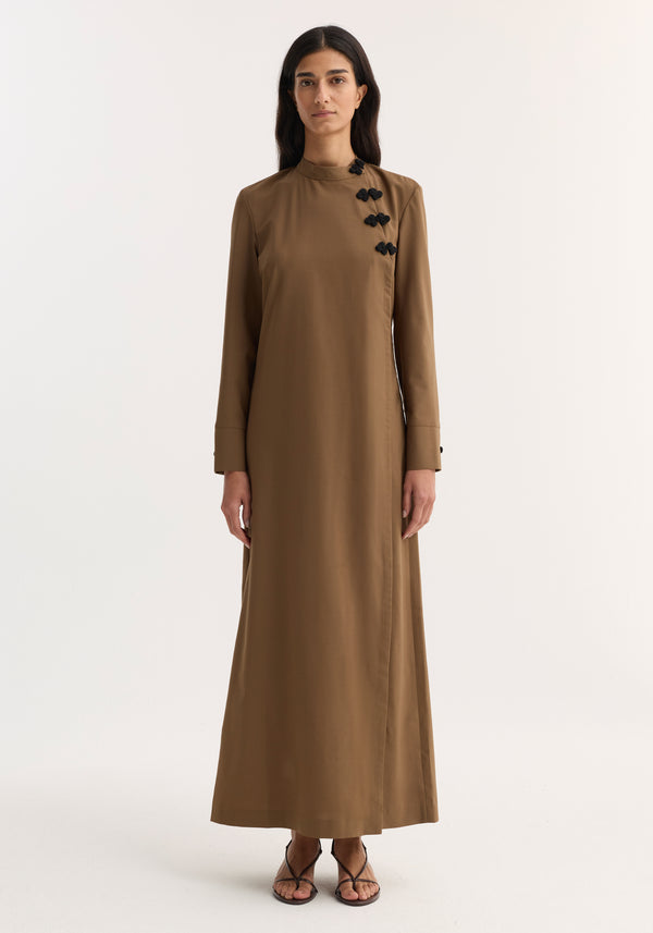 Mandarin Dress | mocha: Woman in full-length, long-sleeved brown dress with asymmetrical pankou closures and side split, paired with black strappy sandals.