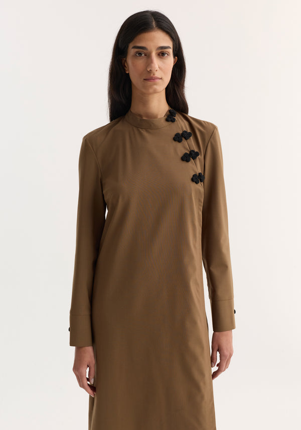 Mandarin Dress in mocha with long sleeves, asymmetrical pankou closures, and side split, modeled by a woman against a light background, showcasing elegant minimalism.