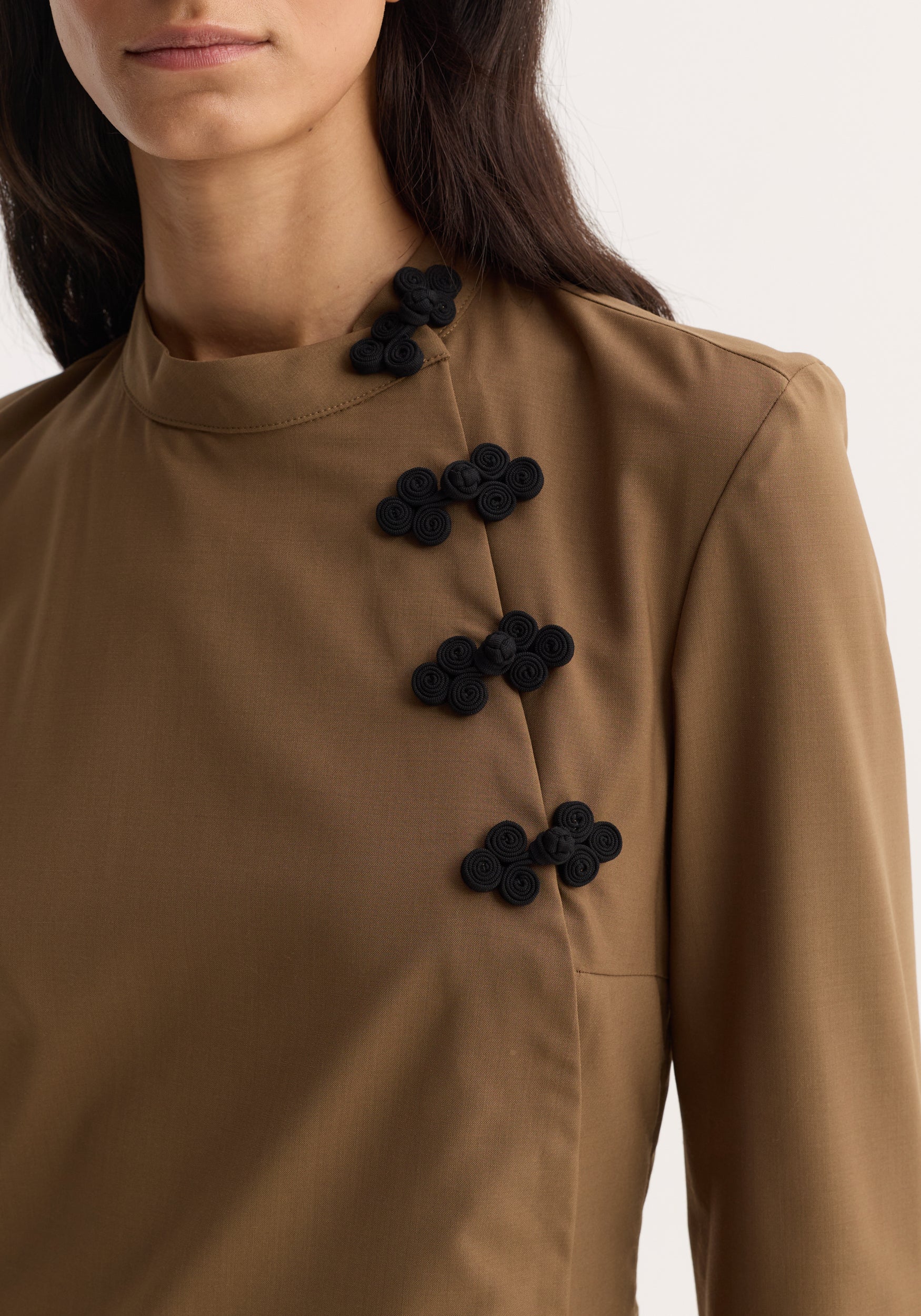 Mandarin Dress | mocha featuring long sleeves, high neck, and decorative asymmetrical pankou closures, highlighting the tunic's modern reinterpretation of traditional elements.