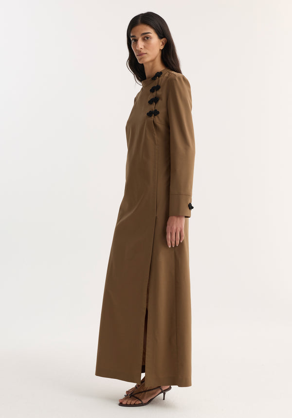 Mandarin Dress | mocha: Woman in profile wearing floor-length, long-sleeved dress with high side slit and pankou closures, paired with black strappy sandals.