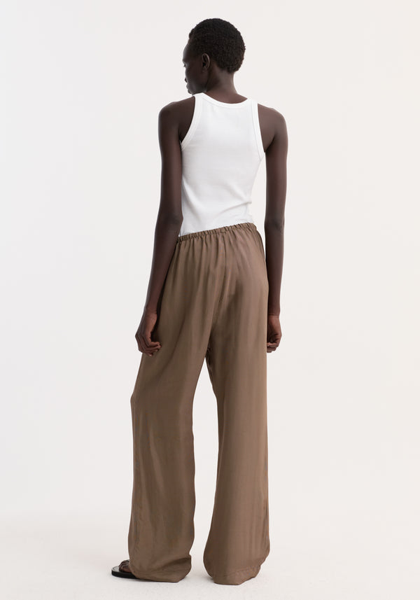 Model wearing Relaxed fit trousers in brown mini check with a loose, wide-leg design, drawstring waistband, and side seam pockets, paired with a white rib-knit tank.