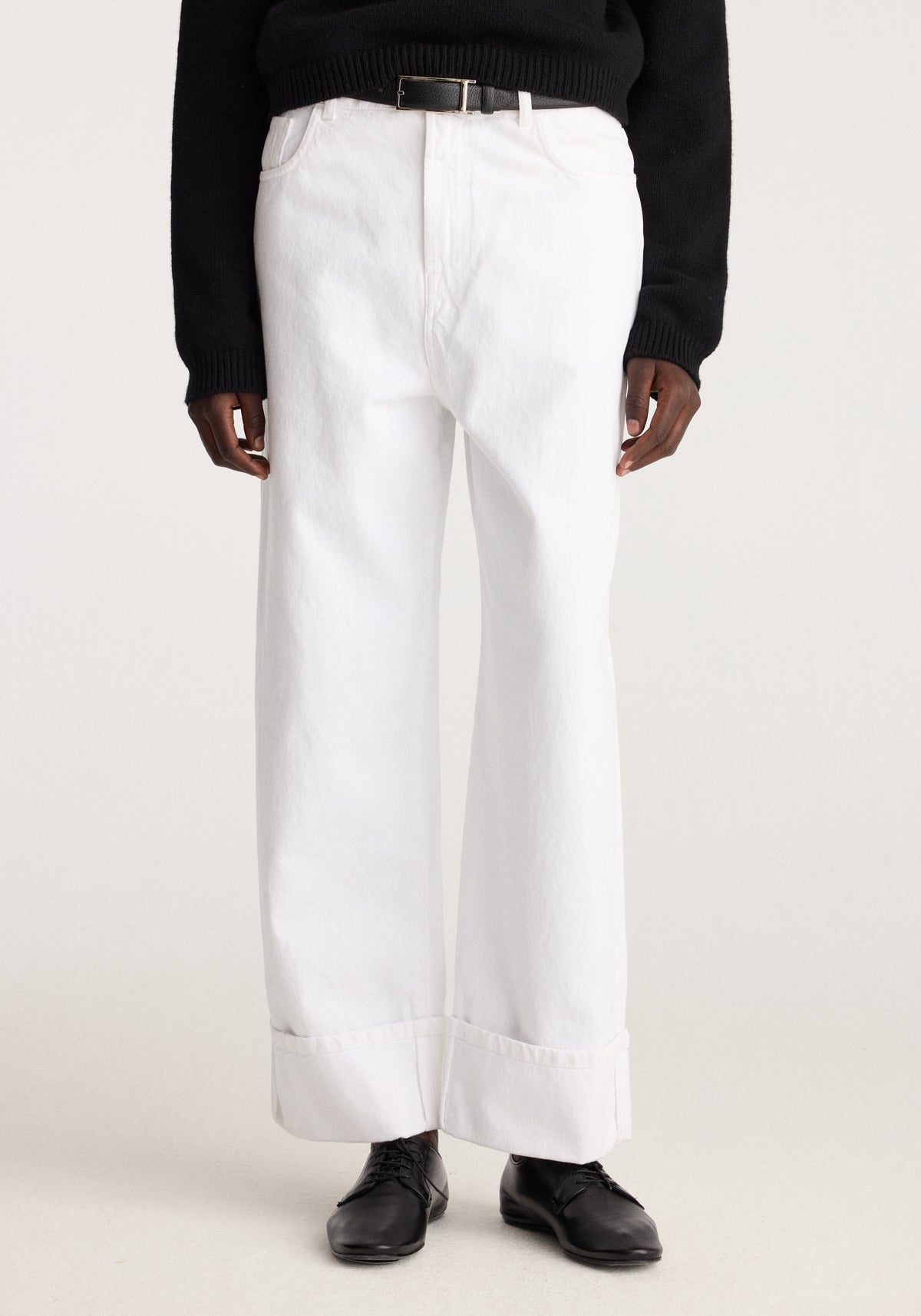 Baggy fit turn-up denim | optic white shown on a model with wide legs and rolled cuffs styled with a black sweater and black leather boots