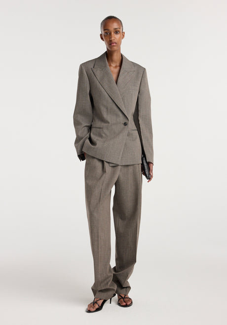 Model wearing an hourglass shaped blazer | earth slub in a neutral brown tone with matching wide-leg trousers and black strappy heels against a plain white background.