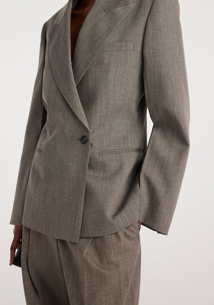 Close-up of a tailored hourglass shaped blazer | earth slub in a textured earth-toned fabric with structured shoulders and a single-button closure.