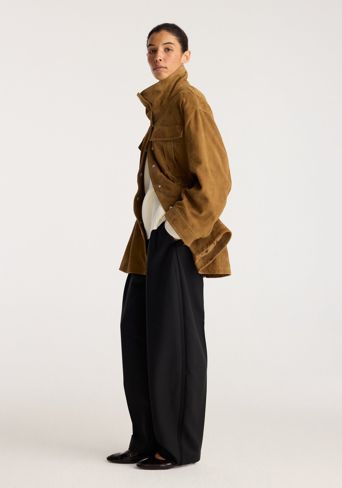 Sculptural suede jacket | sage shown on a model in profile with a cropped structured silhouette high collar patch pockets and long sleeves