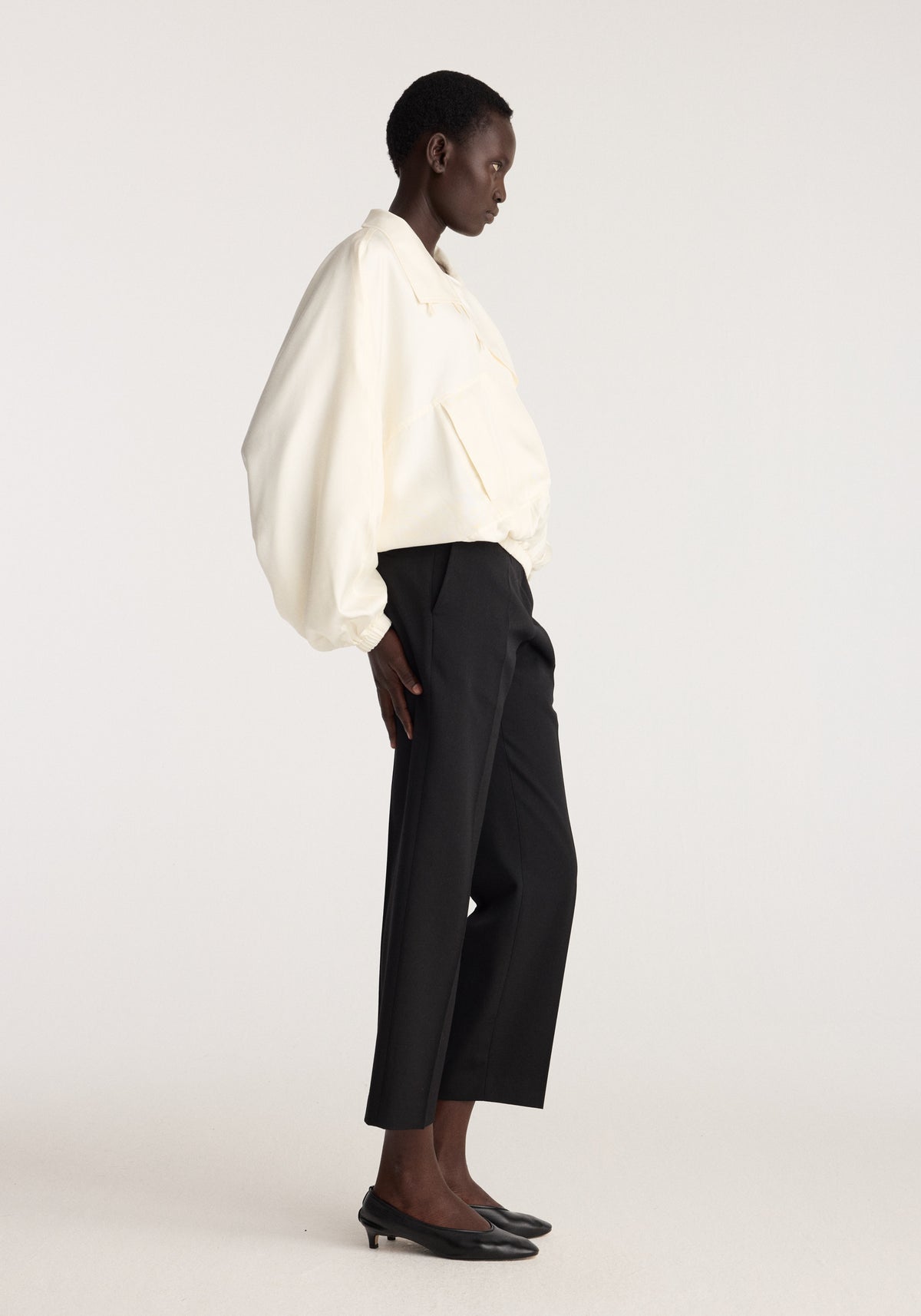 Silk blouson anorak | cream shown on a model in profile with black cropped trousers and black pointed shoes against a neutral background
