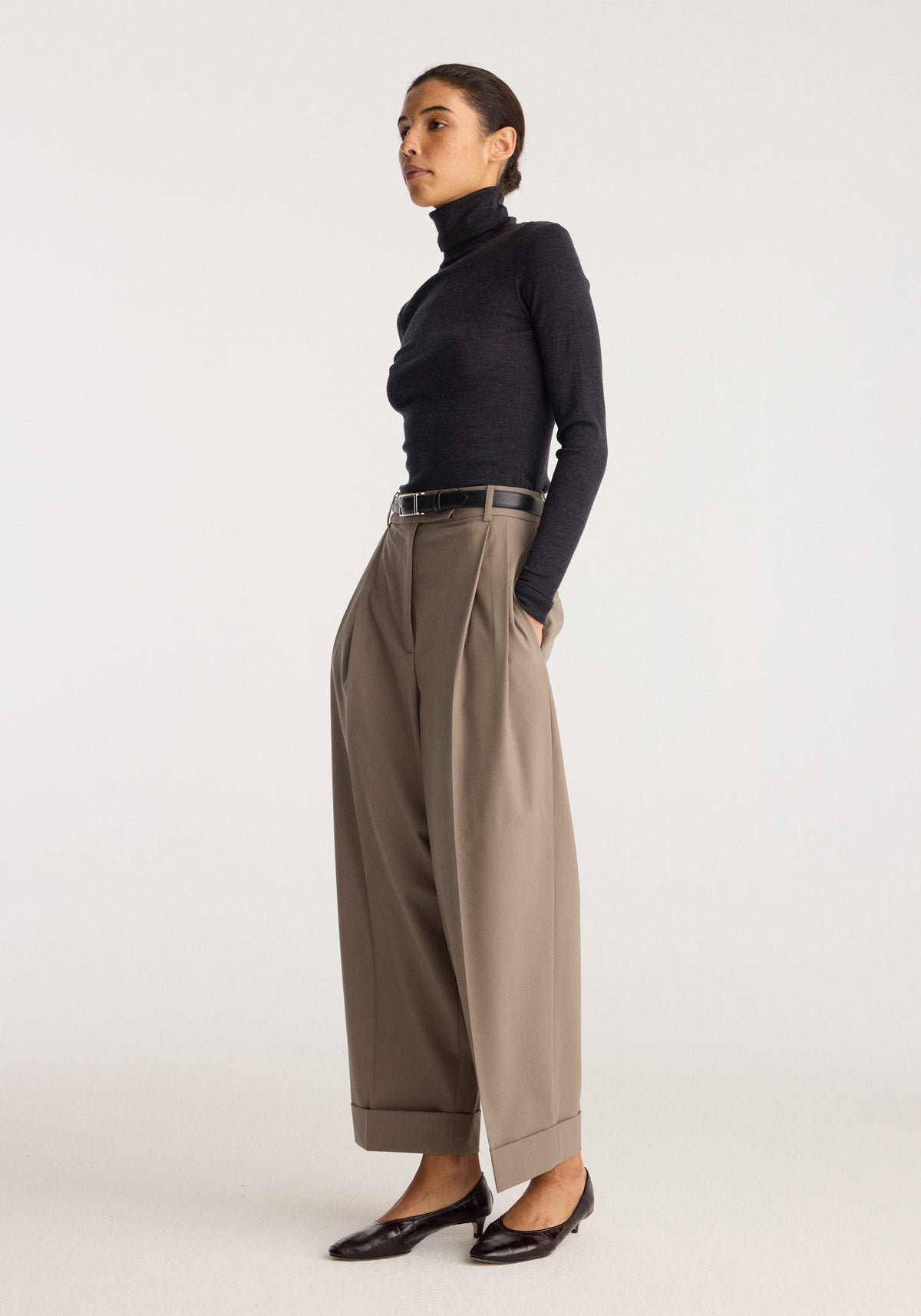 Fine merino turtleneck | anthracite melange worn with wide leg trousers and black loafers on a model in a studio setting