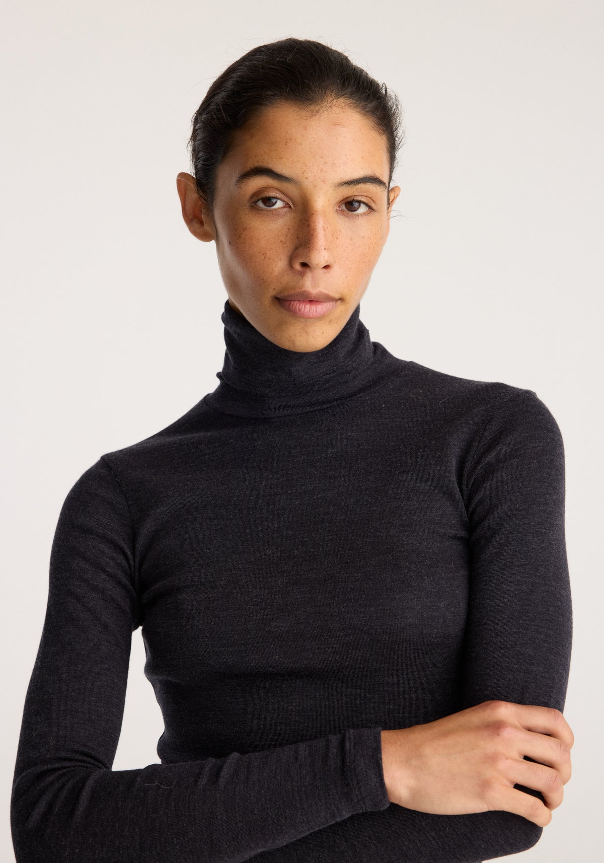 Fine merino turtleneck | anthracite melange worn by a model with long sleeves and a fitted silhouette against a neutral background