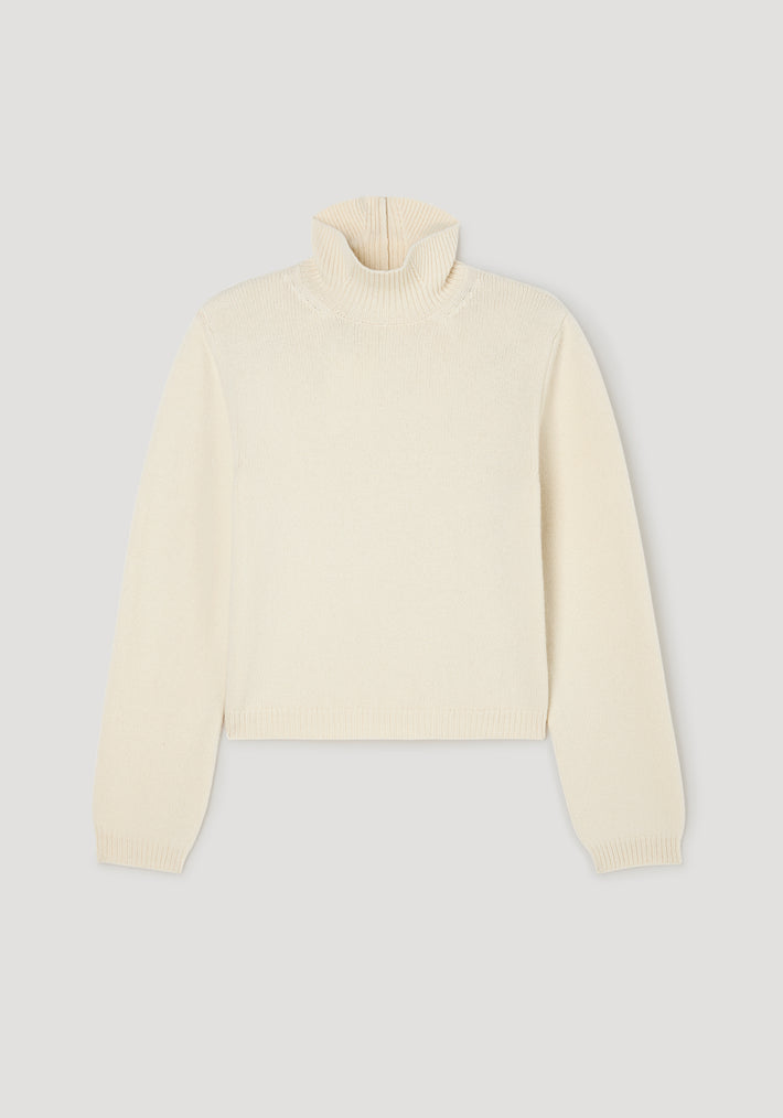 Cream-colored knitted turtleneck sweater with statement shoulders and a cropped hem, featuring long sleeves and a ribbed texture, named Statement shoulder cropped turtleneck | cream.