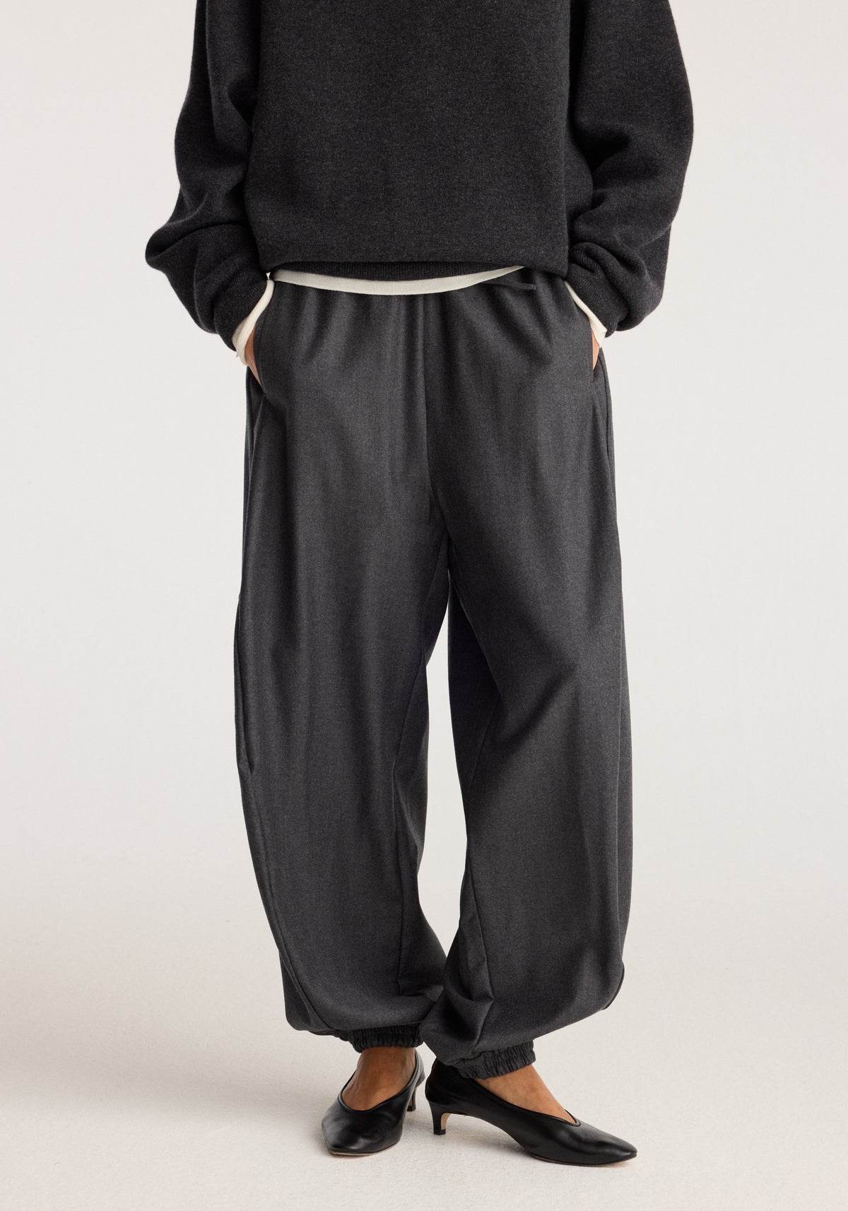 Balloon track pants | dark grey melange styled with a loose fit elastic cuffs and side pockets worn with a dark sweatshirt and black flats