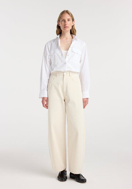 Woman wearing a white button-up shirt paired with beige wide-leg pants, styled with black shoes, showcasing the Berber - Barrel leg denim | ecru.