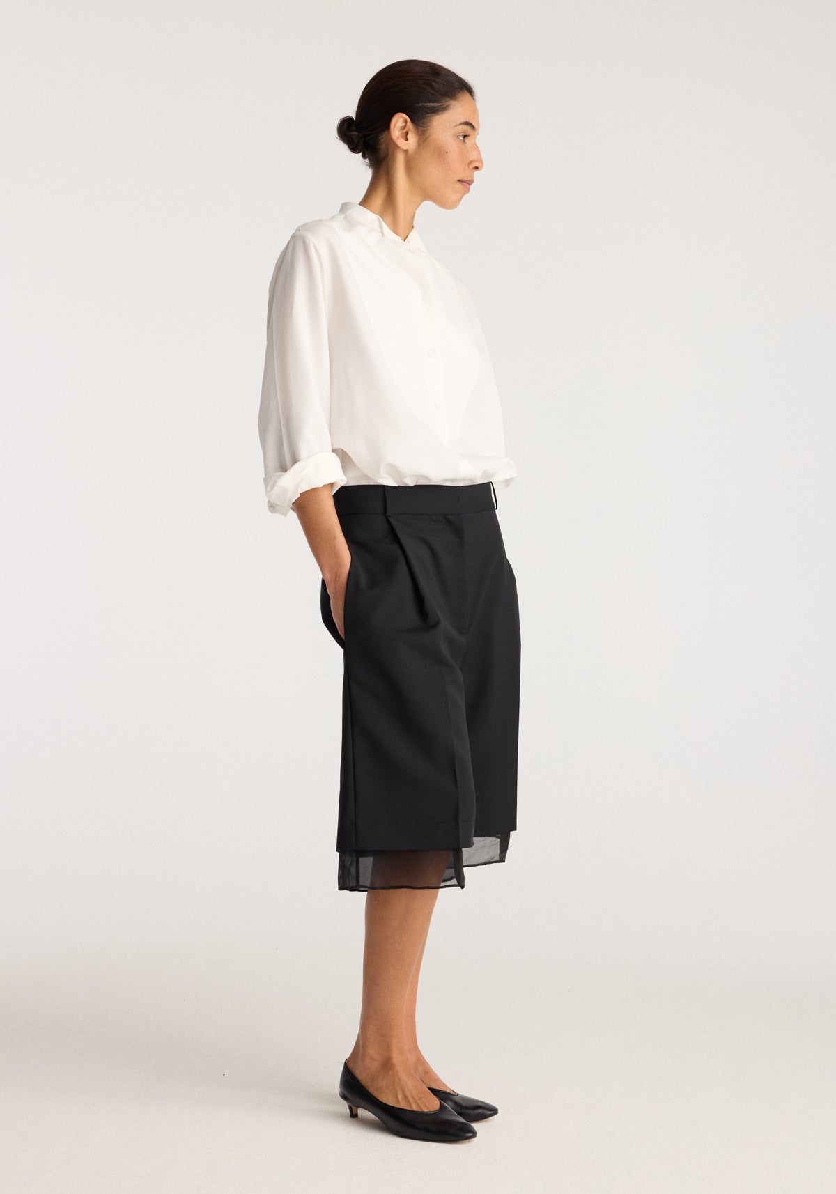 Model wearing Organza lined shorts | black with a sheer organza overlay, styled with a white blouse and black flats