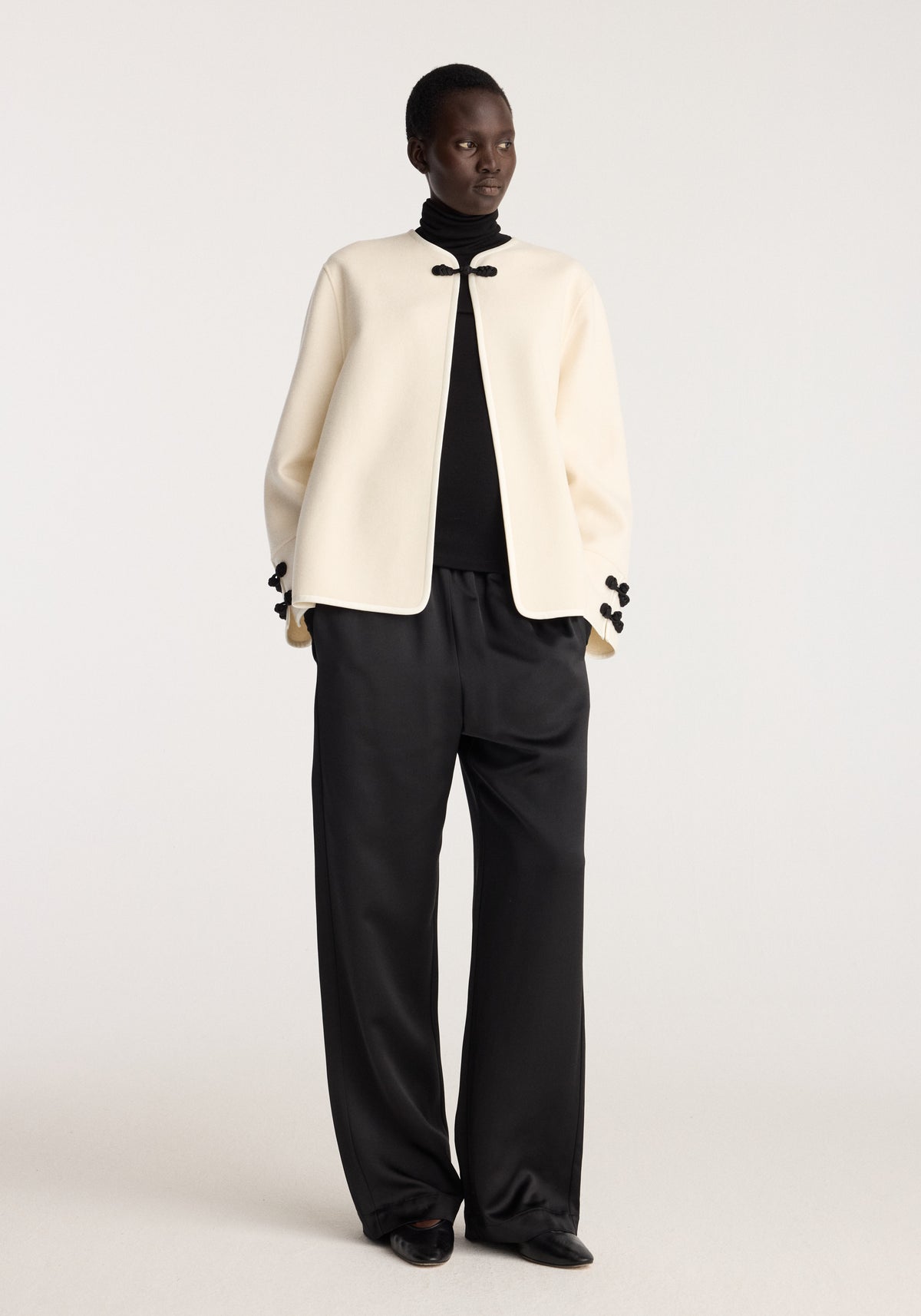 Double-faced pankou jacket | off white worn with black top and wide leg trousers, featuring rounded front edges and traditional pankou closures on the collar and cuffs