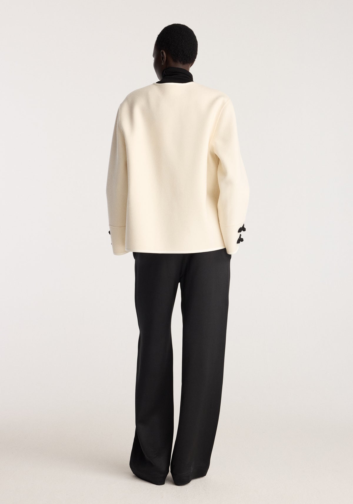 Double-faced pankou jacket | off white shown from the back on a model with a relaxed fit and long sleeves styled with black trousers