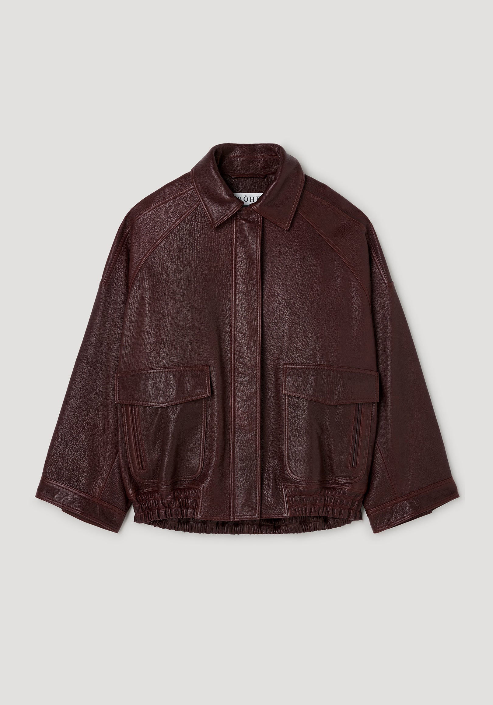 Grain leather aviator jacket | chestnut in rich dark brown with textured finish, featuring a classic collar, front flap pockets, and elasticized hem, laid flat on a light background.