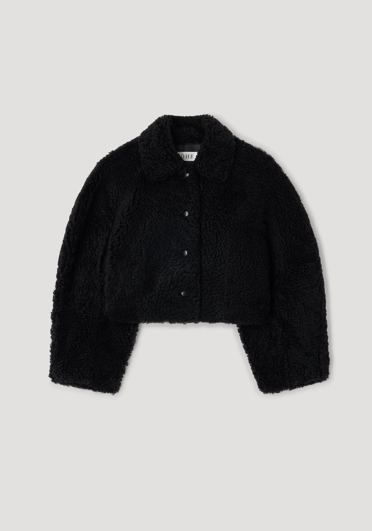 Rounded shearling jacket | black displayed flat, featuring a soft textured fabric with a folded collar and front button closures.