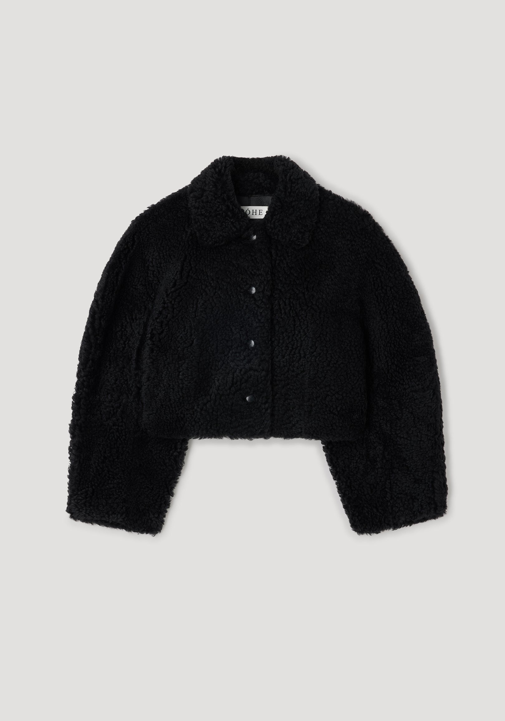 Rounded shearling jacket | black displayed flat, featuring a soft textured fabric with a folded collar and front button closures.