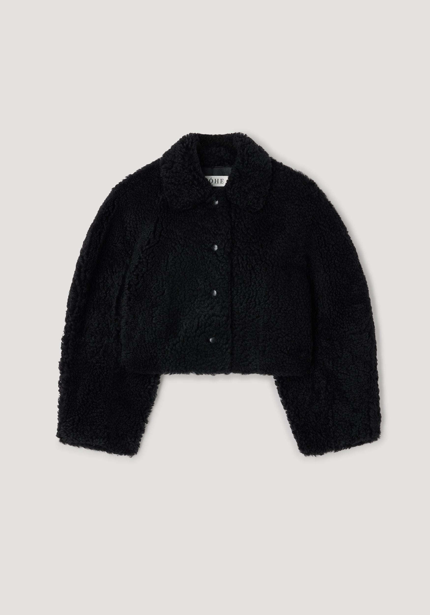 Rounded shearling jacket | black displayed flat, featuring a soft textured fabric with a folded collar and front button closures.