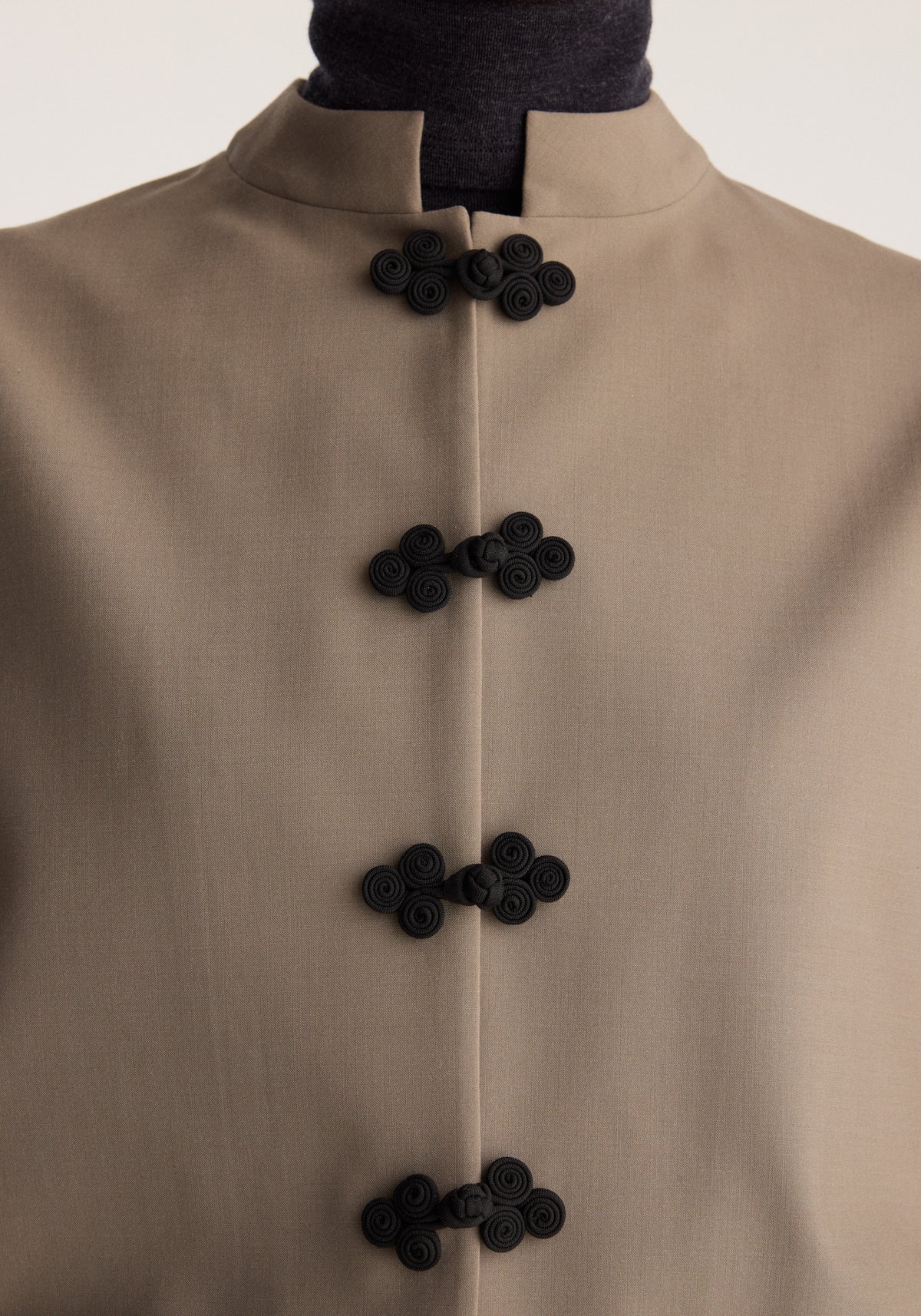 Pankou closure jacket | taupe shown in close up with a high collar and four black decorative knot closures down the front