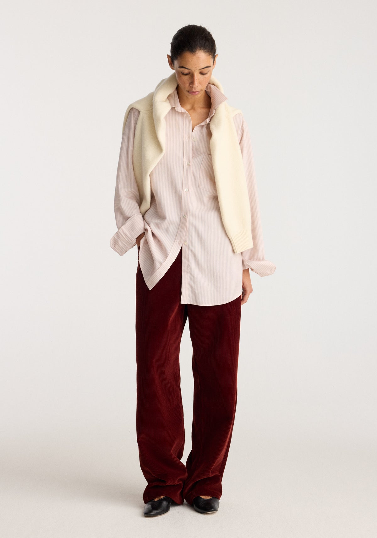 Classic fit striped shirt | rose stripe worn by a model with burgundy trousers and a cream vest in a full length studio portrait