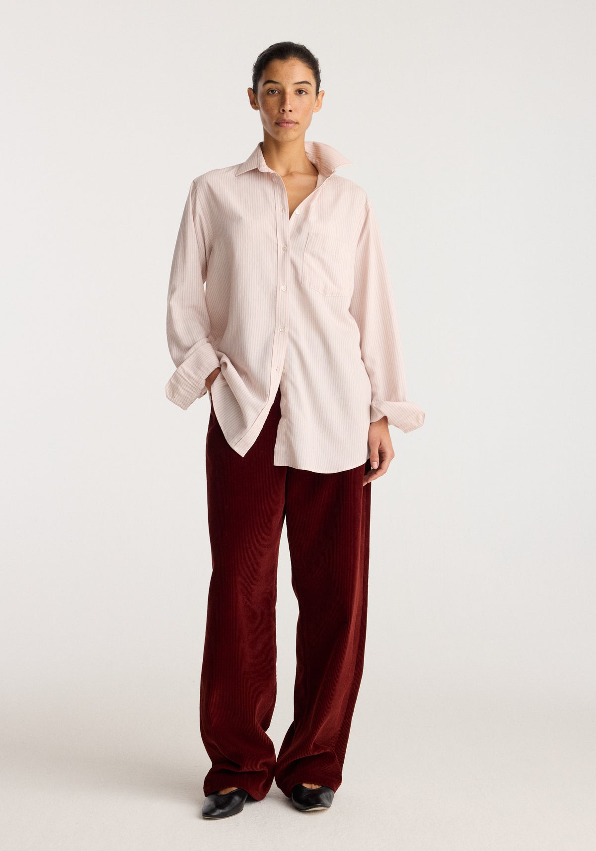 Classic fit striped shirt | rose stripe worn by a model in a relaxed fit with button front collar and long sleeves styled with burgundy trousers