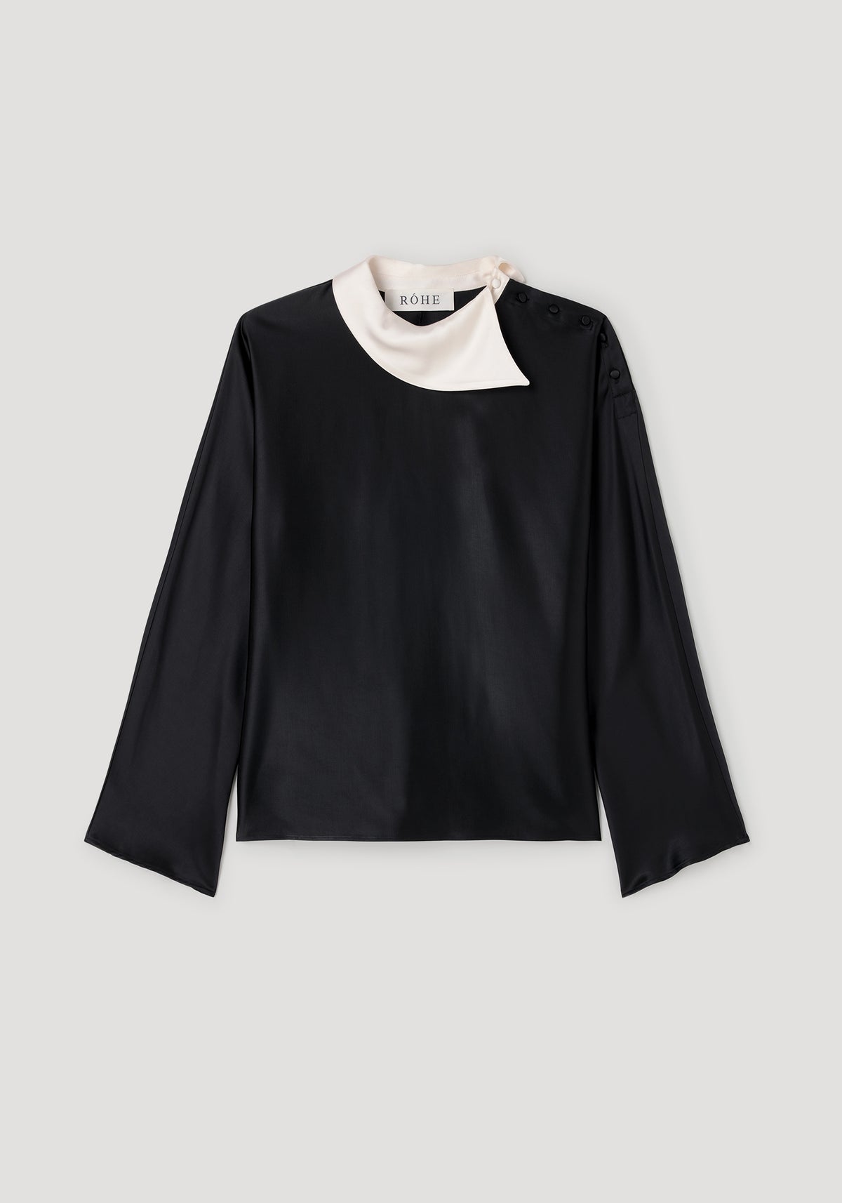 Black long-sleeve top featuring a contrasting white asymmetrical collar with button details, designed as the Reimagined collar top | black.