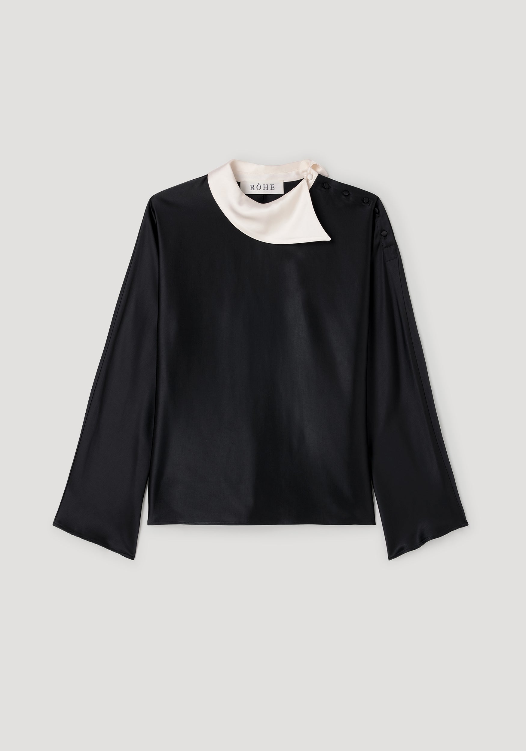 Black long-sleeve top featuring a contrasting white asymmetrical collar with button details, designed as the Reimagined collar top | black.