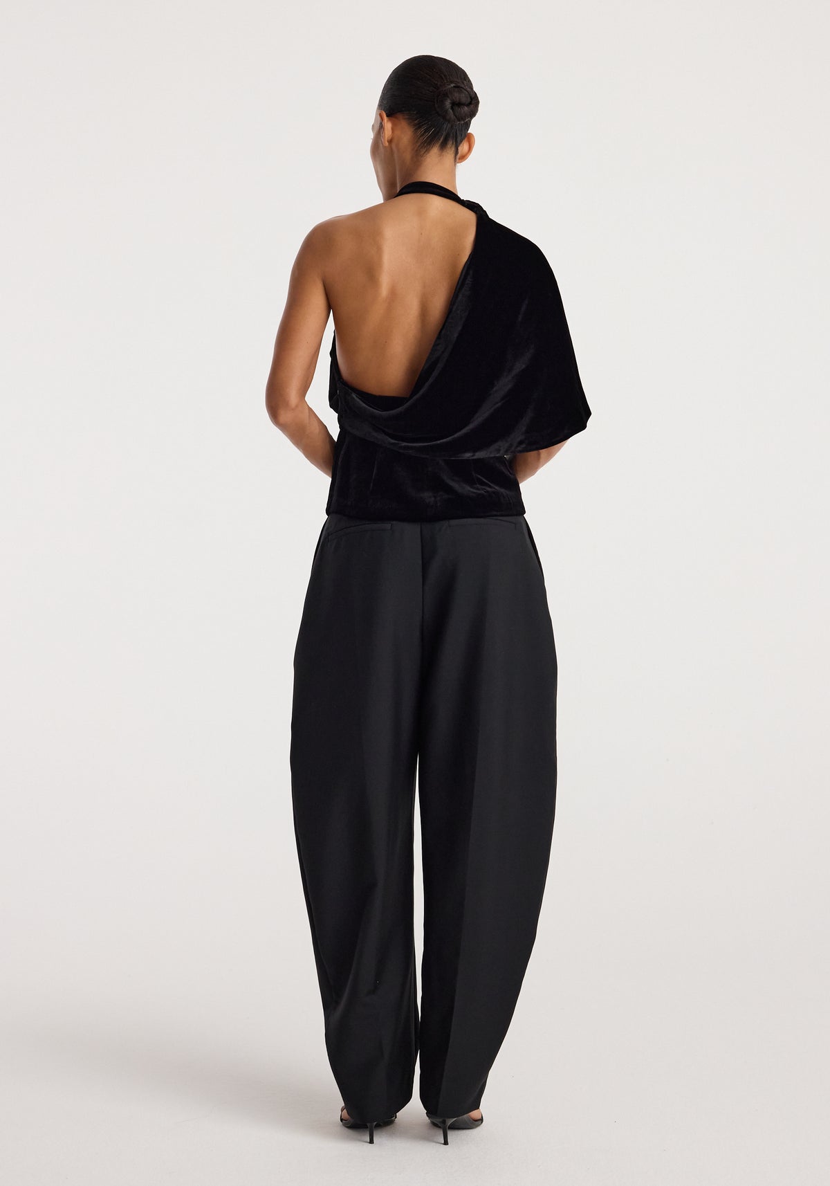 Back view of a model wearing Draped open back silk velvet top | black, showing its draped open back and relaxed black silhouette.