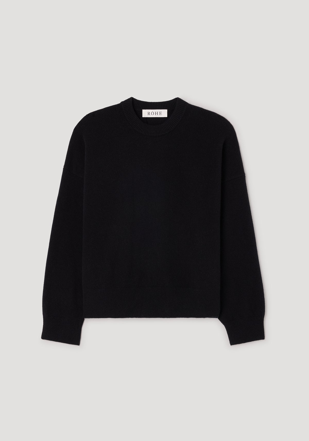 Classic crewneck jumper | black laid flat on a light background, featuring a simple and timeless design with long sleeves and ribbed edges at the neckline, cuffs, and hem.