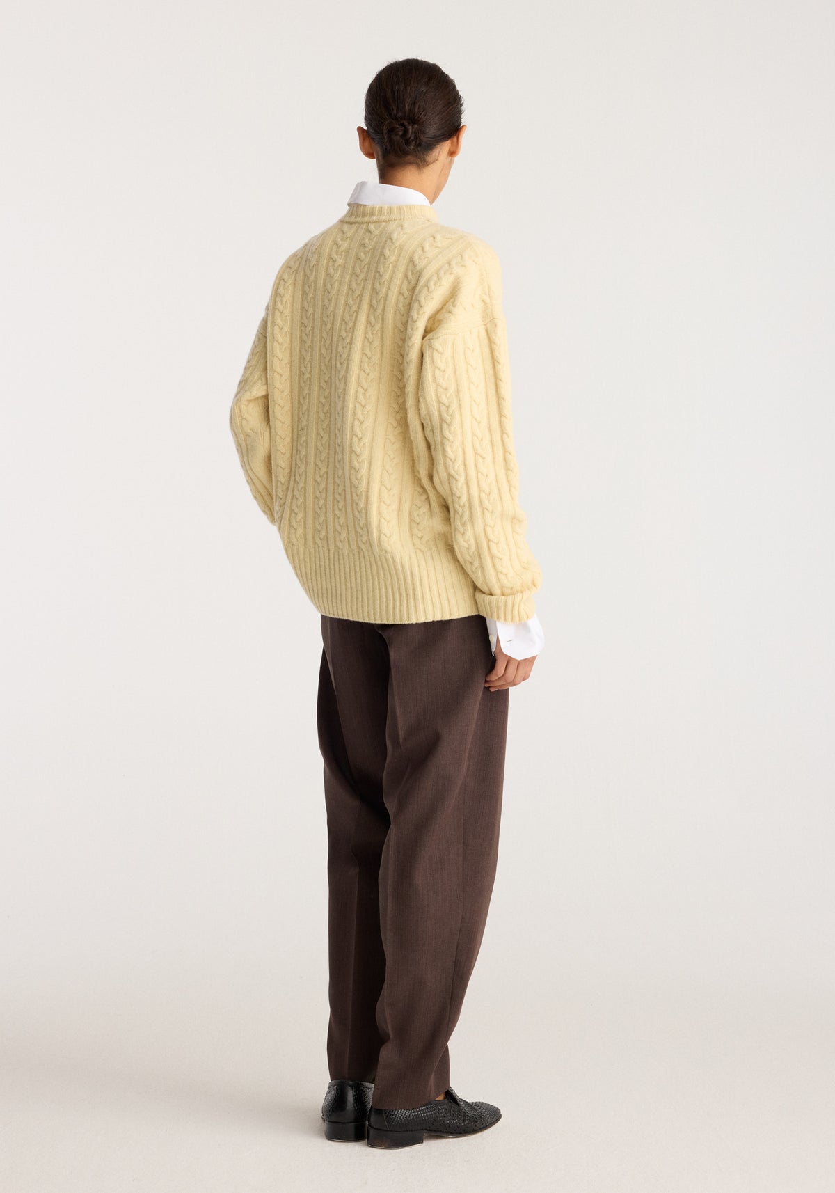 Cable knit jumper | butter shown from the back on a model with a textured cable knit pattern and relaxed fit