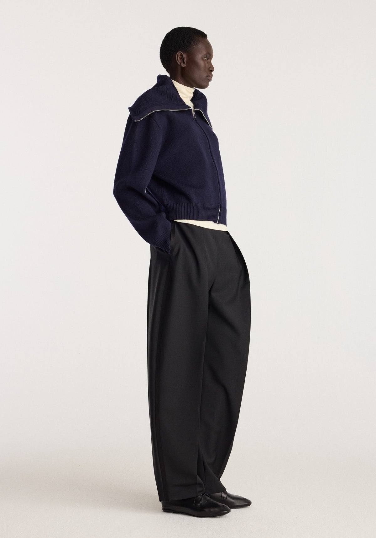 Reversible sailor zip cardigan | navy shown on a model in profile with a high collar and zip front styled with black trousers